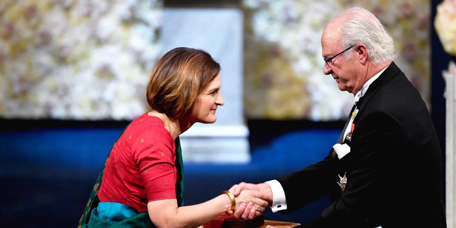 Esther Duflo tar emot ekonomipriset till Alfred Nobels minne av kung Carl Gustaf under Nobelprisutdelningen i Konserthuset i Stockholm på tisdagen.