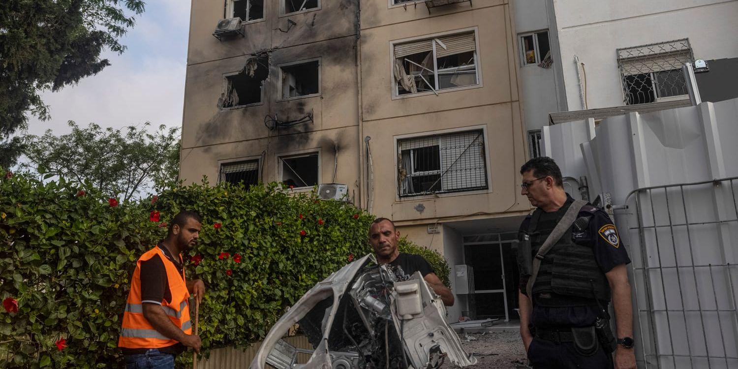 Förstörda hushållsapparater bärs ut från det träffade huset i israeliska Ashkelon.