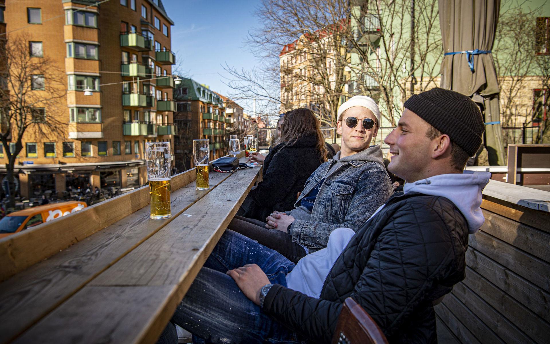 Erik Brorsson och Hjalmar Svensson, som sitter på Linnéterrassen, njuter av att uteserveringarna öppnats extra tidigt i år. 