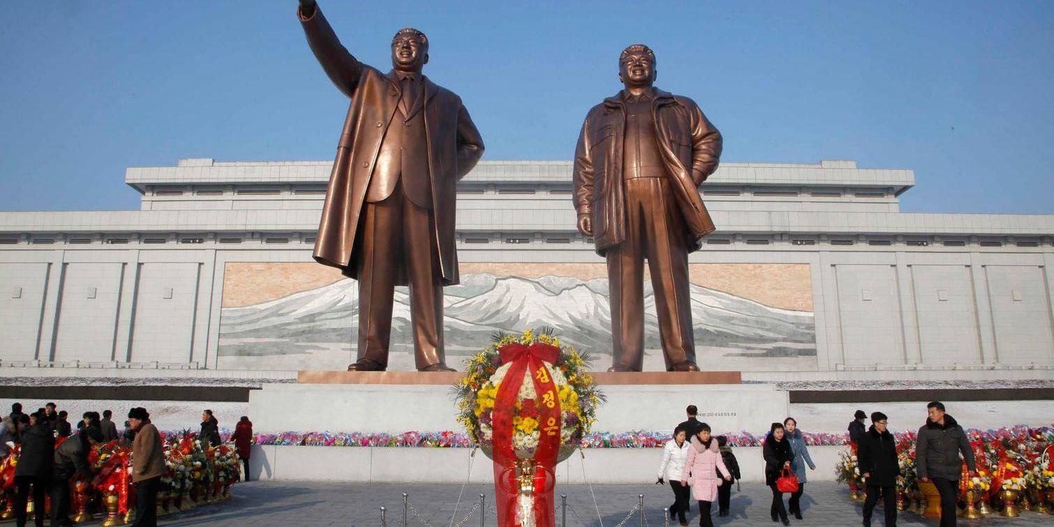 Blomsterhav framför statyerna av Kim Il-Sung och Kim Jong-Il.