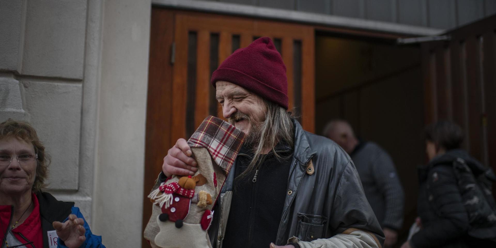 Sven får en julstrumpa av volontären Irene Hollster.