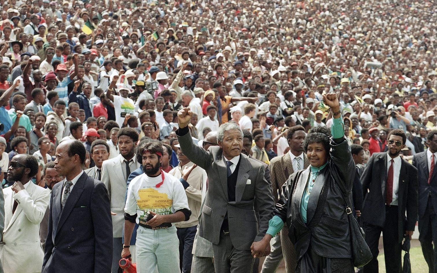 Februari 1990. Nelson Mandela har släppts ur fängelset efter mer än 27 år bakom galler. Förändringens vindar blåser i landet när han och hans fru Winnie gör black power-hälsningen mot de tusentals åskådarna i Soccer City Stadium, Johannesburg.