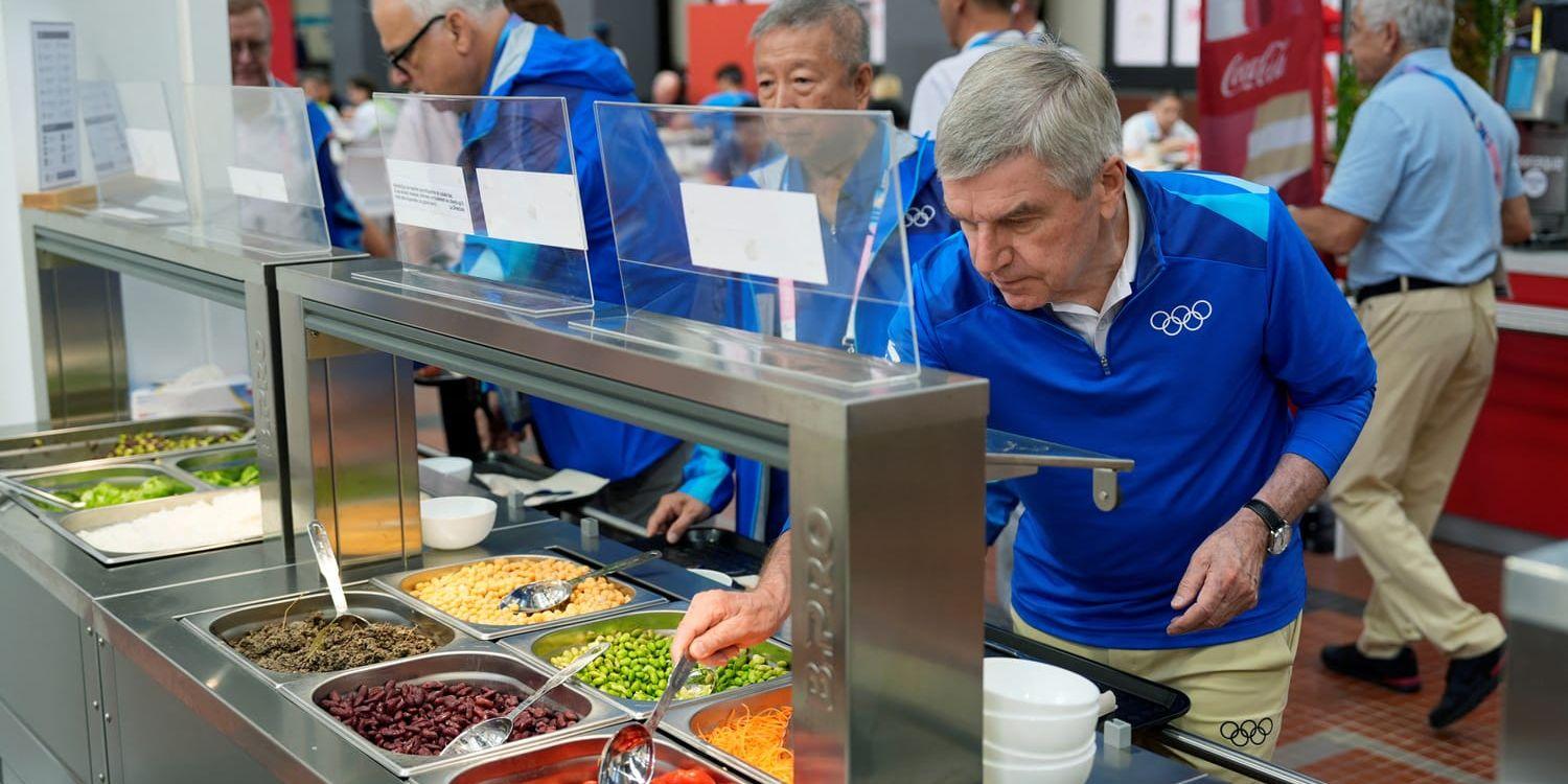 Thomas Bach, ordförande i IOK tar till sig av tomaterna i OS-byn.