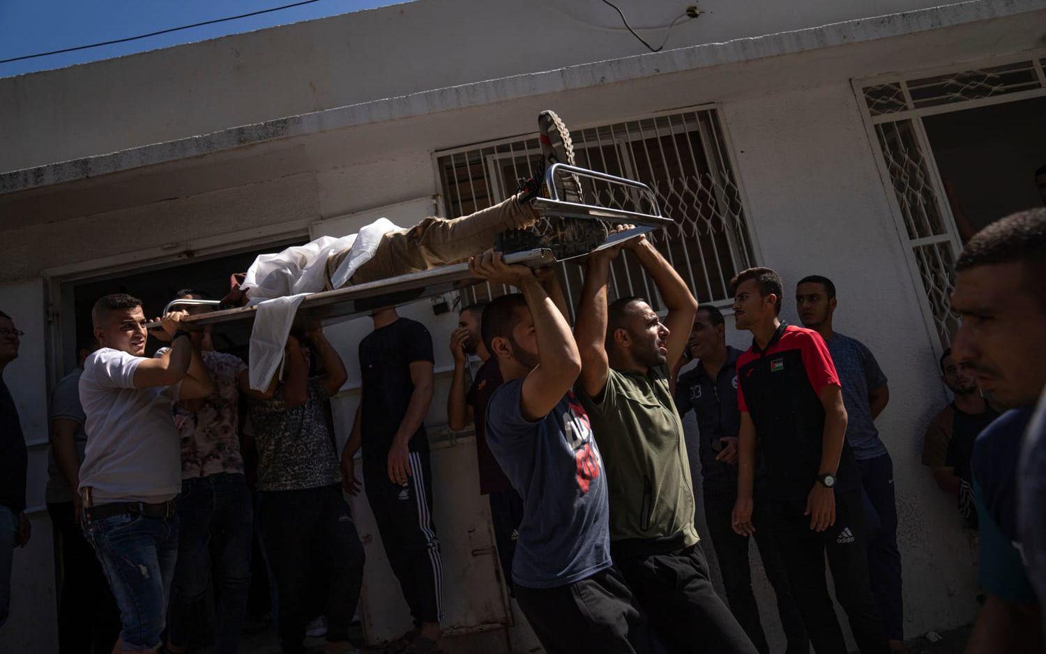 Palestinier bär bort en död person efter Israels motangrepp i Gaza.