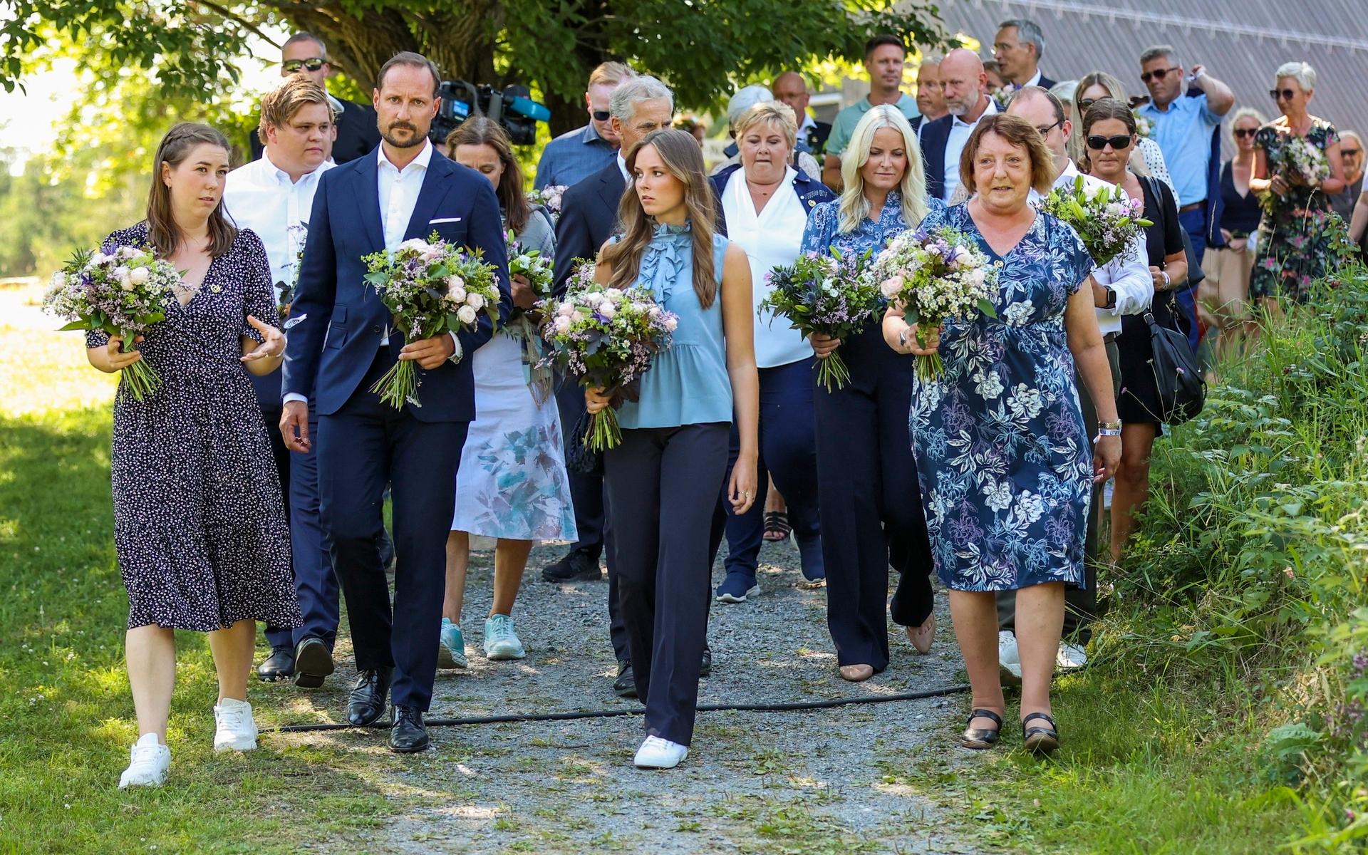 Ordförande Astrid Willa Eide Hoem, kronprins Haakon, Ingrid Alexandra, statsminister Erna Solberg, kronprinsessan Mette Marit och Lisbeth Kristine Röyneland under minneceremonin på Utöya då många lade blommor vid minnesmärket som är format som en stålring.