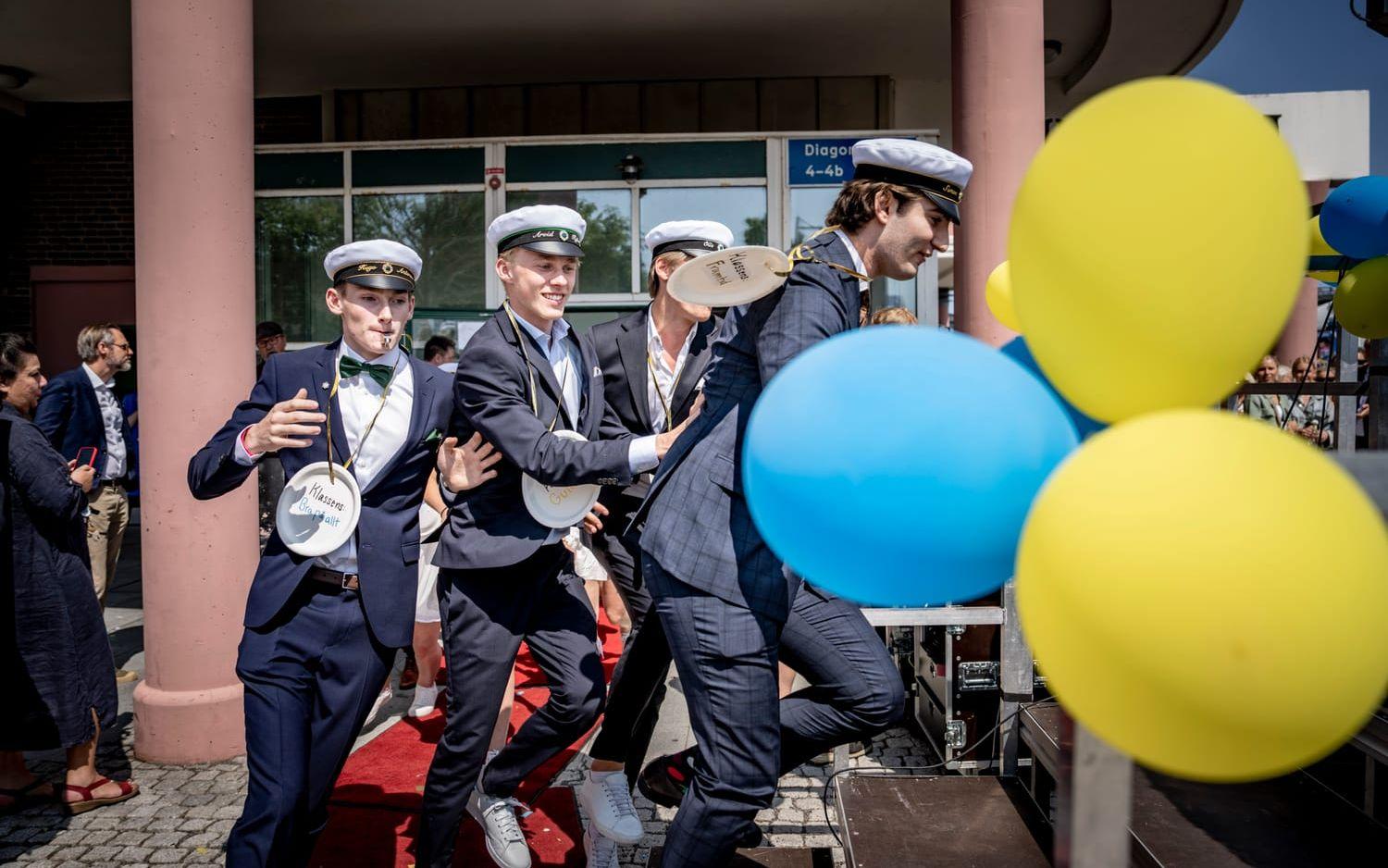 Ballonger och killar med flärd i steget vid studentfirandet på Polhemsgymnasiet.