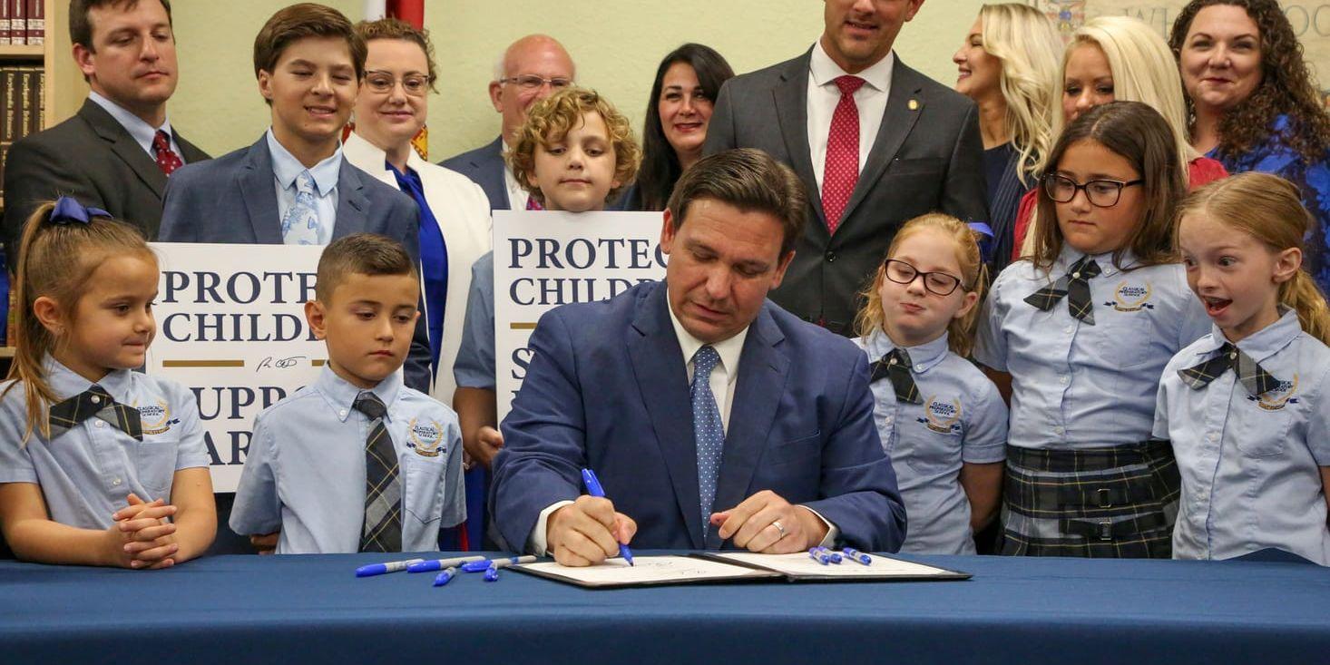 Floridas guvernör Ron DeSantis skrev under lagen omgiven av barn på en skola i Shady Hills.