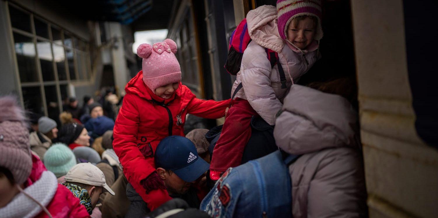 Människor i huvudstaden Kiev försöker ta sig ombord på ett tåg till Lviv under måndagen.