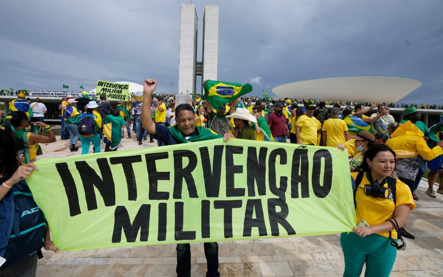 Demonstranterna håller upp skyltar med texten ”militär intervention”.