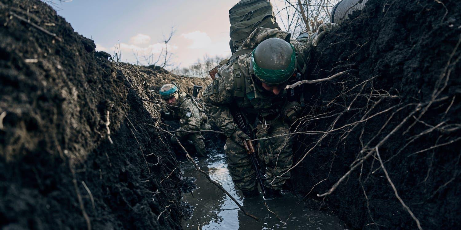 Ukrainska soldater tar skydd i en skyttegrav under rysk beskjutning nära Bachmut. Wagnergruppen kastar våg efter våg av soldater mot de ukrainska ställningarna.